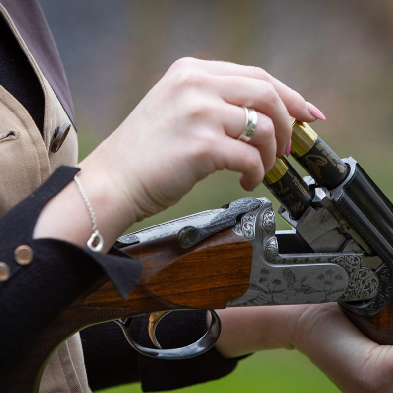 LOGIN & ACCESS ALL - Woman loading shotgun cartridges.
